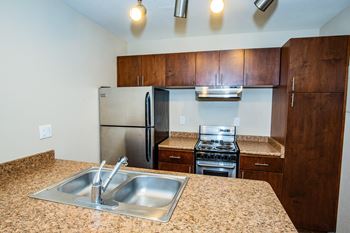 A kitchen with granite countertops and stainless steel appliances.